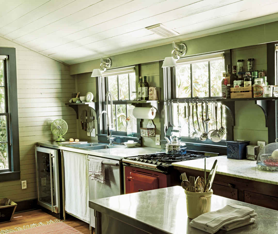 WORKING WINDOWS. The couple’s large utensils hang from hooks on a metal rod in the window; it’s a small investment that’s both attractive and handy.