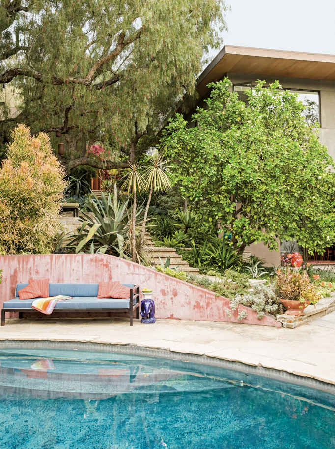RAW MATERIALS. The pinkish-red hue of the dividing wall comes from pigmented (not painted) concrete, meaning the color is stirred right into the cement mix. The walls will age gracefully, revealing beautiful new tones the more weathered they get.